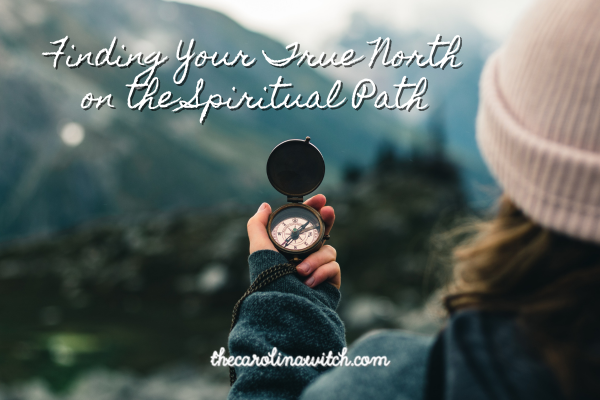 Finding Your True North on the Spiritual Path blog post title with a picture of a woman standing out in nature in front of a mountain range. She is holding a compass.